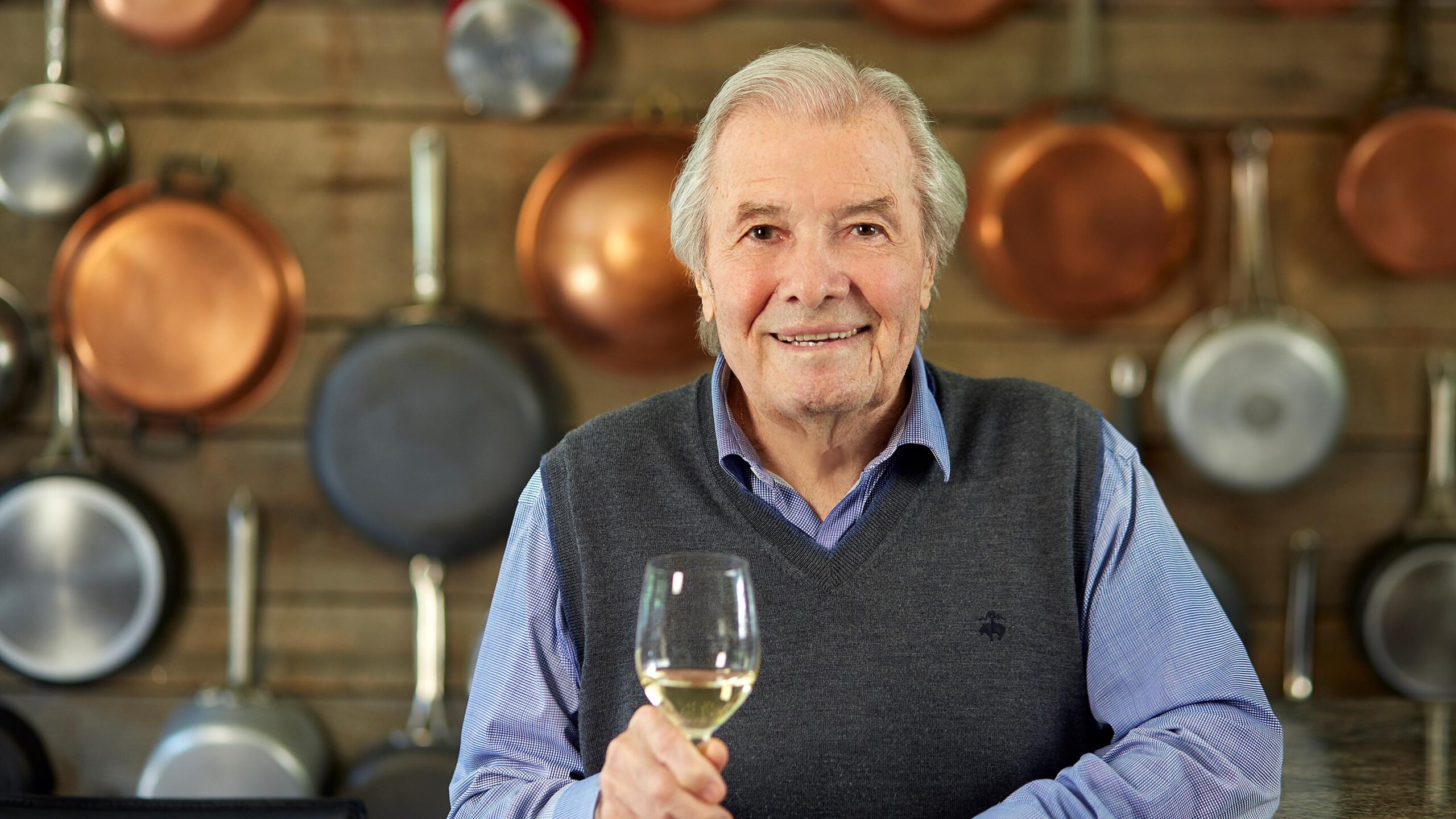 Jacques Pépin holding a glass of wine