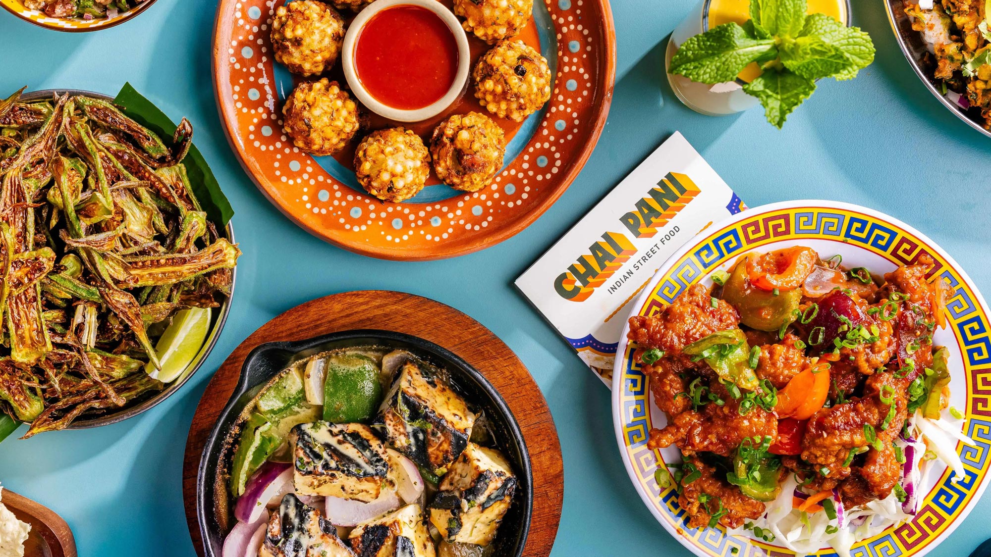 Overhead view of table featuring dishes prepared at Chai Pani restaurant