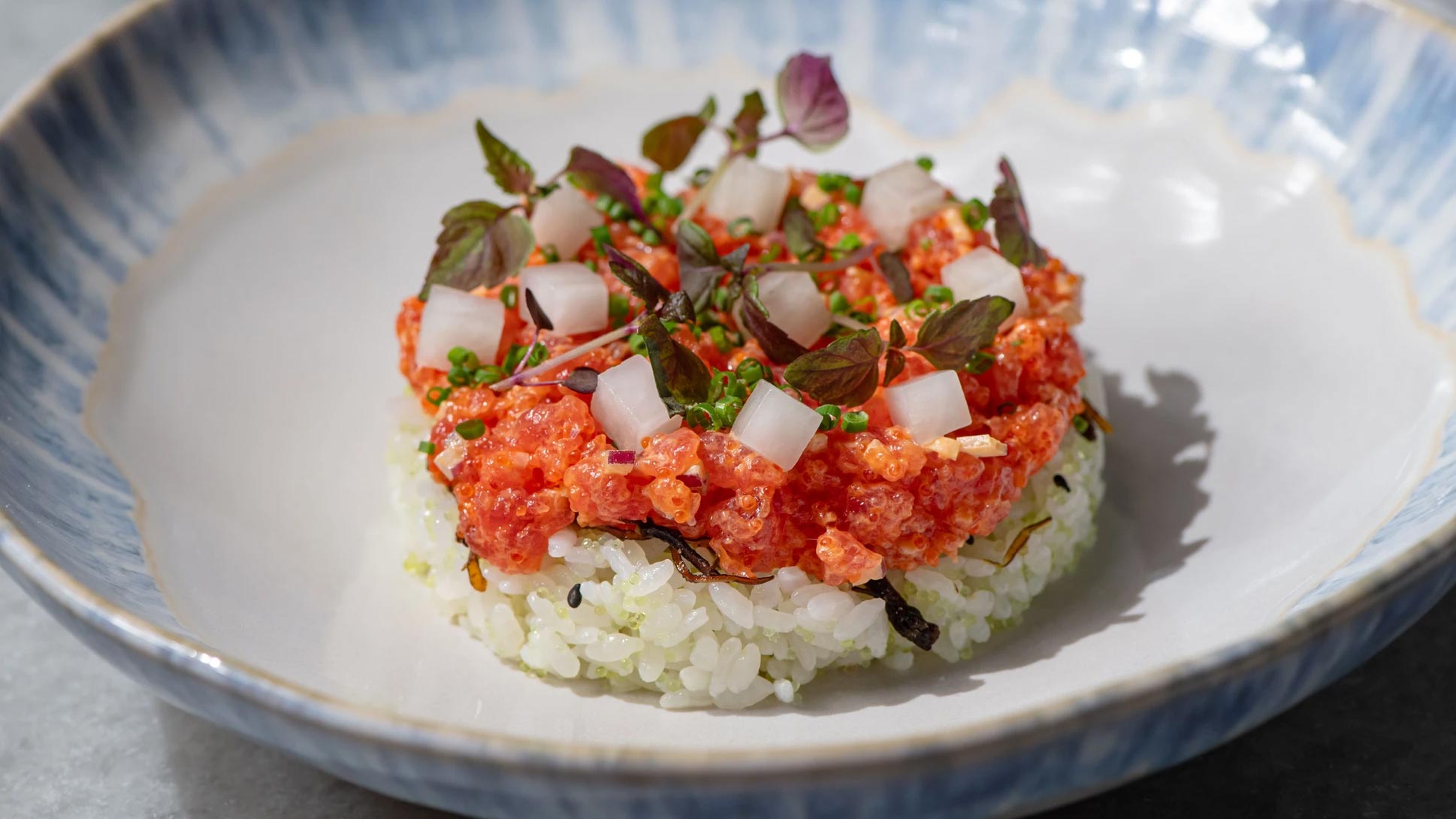 Salmon dish with assorted toppings on a bed of rice