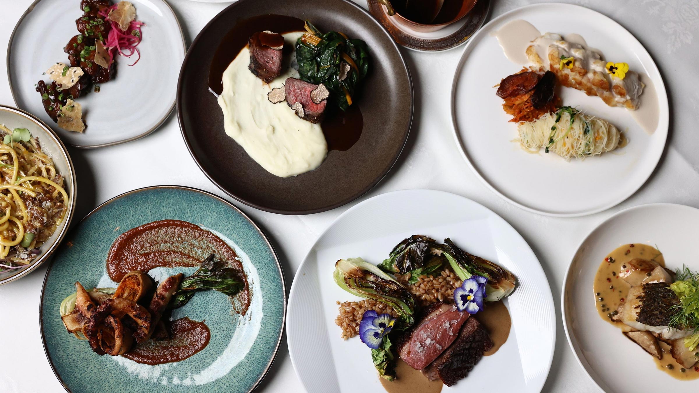 Overhead view of a dining room table with several plates of food at Yono's